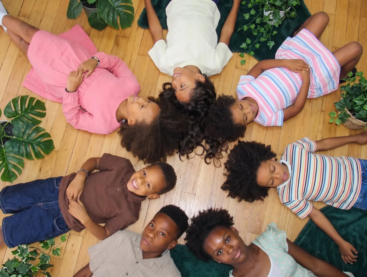 Coiffure enfant cheveux bouclés à Montréal : sept enfants aux cheveux bouclés et crépus allongés en cercle, Boucles Addict Studio