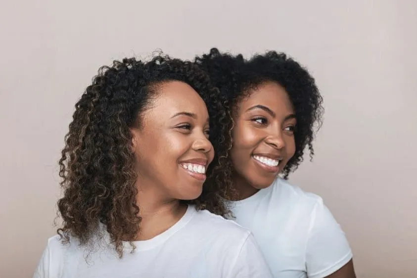 Deux clientes aux boucles afro qui sourient, salon afro à Montréal